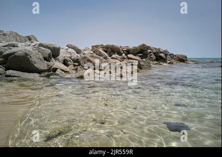 Panorama mit felsigen Strand mit Felsen und kristallklarem Wasser im Sommer. Stockfoto