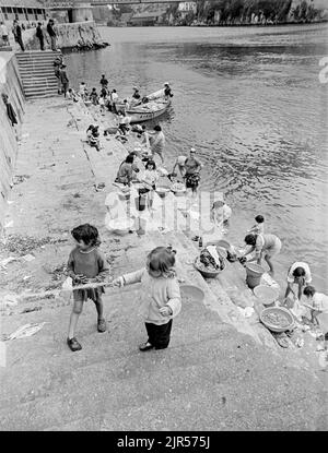 PORTUGAL - PORTO - 1970. Frauen und Kinder waschen ihre Kleidung im Fluss Douro an der Küste von Cais da Ribeira im Stadtteil Ribeira von Porto, N Stockfoto