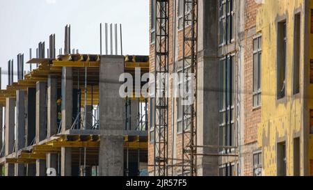 Bauarbeiter auf den Etagen eines Wolkenkratzers. Männer, die ein neues Business Center in den oberen Stockwerken aufmachen. Stockfoto