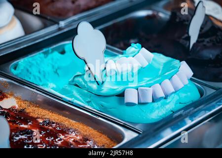 Eis in verschiedenen Farben und Geschmacksrichtungen im Kühlschrank im Fenster eines Dessertladens oder einer Eisdiele in Italien. Leckeres und leckeres Eis im Café Stockfoto