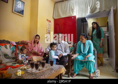 Indische Familienmitglieder sitzen im Wohnzimmer Stockfoto