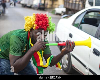 Ein kamerunischer Fan freut sich am 14. Januar 2022 auf einer Straße in Libreville während des Kamerun-Äthiopien-Spiels zum Afrikanischen Cup der Nationen 2021. Stockfoto