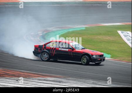 Ein schwarz-roter BMW E36 driftet während eines Rennens Stockfoto