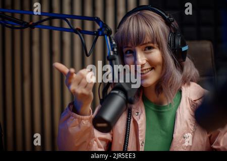 Porträt einer Sprecherin im Radio, die während der Moderation einer Live-Show im Mikrofon spricht Stockfoto