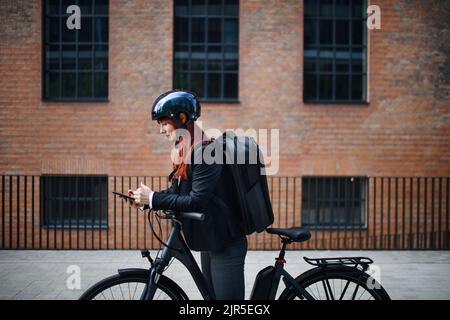 Porträt einer Geschäftsfrau, die Pendlerin auf dem Weg zur Arbeit mit einem Fahrrad, einem nachhaltigen Lifestyle-Konzept. Stockfoto