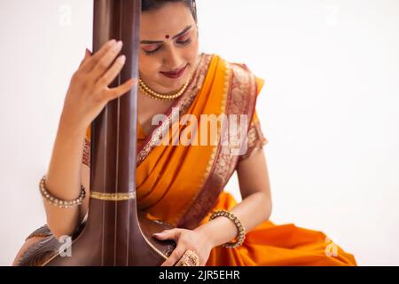 Nahaufnahme einer jungen Frau, die Tanpura spielt Stockfoto