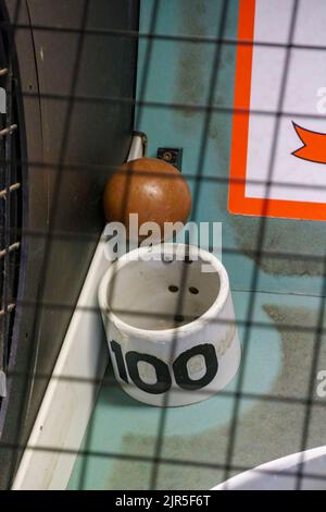 Ein Skee-Ball wird durch das Loch mit 100 Punkten (höchste Punktzahl) eingekeilt Stockfoto