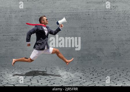 Geschäftsmann läuft mit Megaphon auf grauem Hintergrund. Werbekonzept. Stockfoto