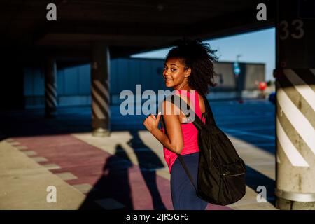 Multirassische Teenager-Mädchen zu Fuß mit Rucksack in der modernen Stadt während des Sommers, zurück zur Schule Konzept. Stockfoto