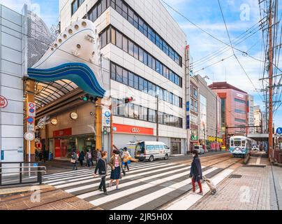 nagasaki, kyushu - 12 2021. dezember: Menschen, die auf der Fußgängerüberführung der Straßenbahnhaltestelle Hamamachi Arcade vor dem Eingang von Hamanom spazieren Stockfoto