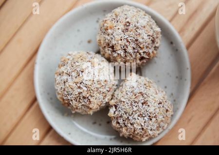 Vegane handgemachte Gluten- und zuckerfreie Delight - natürliche Süßwaren-Kugeln auf dem Holztisch aus nächster Nähe. Gesundes Dessert. Rohkost Stockfoto