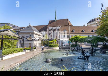 Der Fasnachts-Brunnen oder Tinguely-Brunnen auf dem Theaterplatz und die Kirche Elisabethen in Basel, Schweiz, Europa | Tinguelys Fasnachtsbrunnen Stockfoto