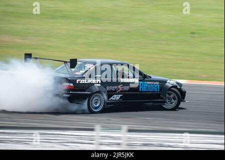 Ein schwarzer BMW E36, der Rauch auf einer Spur für einen Drift-Wettbewerb erzeugt Stockfoto