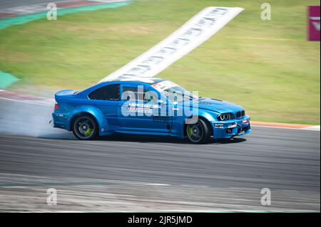 Ein blauer BMW E46, der Rauch auf einer Spur für einen Drift-Wettbewerb erzeugt Stockfoto