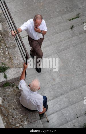 Straßenfotografie Gespräch von zwei alten Männern in einem Dorf im Westen Siziliens, Italien Stockfoto