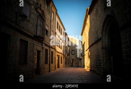Zentrale Straße der Altstadt von Ubeda in Jan, Andalusien, Spanien. Beleuchtet bei Sonnenuntergang mit Kirche auf einer Seite Stockfoto
