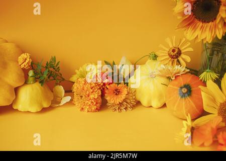 Stylische Herbstkomposition. Bunte Blumen, Kürbis, Pattypan Squash auf gelbem Hintergrund. Kreatives modernes herbstliches Stillleben. Seasons begrüßt Auto Stockfoto