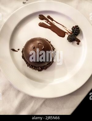 Eine runde, minimalistische Sacher-Torte auf einem weißen Teller Stockfoto