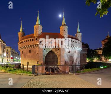 Steingebäude des Barbican Fort in Krakau in der Nacht Beleuchtung in der Dämmerung. Polen. Stockfoto