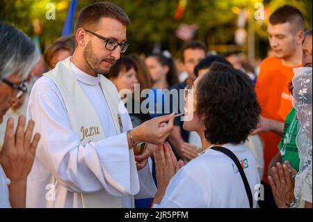 Ein Priester, der den Gläubigen die heilige Kommunion gibt. Stockfoto