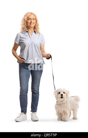 In voller Länge Porträt einer reifen Frau mit einem maltesischen Pudel Hund auf einer Blei isoliert auf weißem Hintergrund Stockfoto