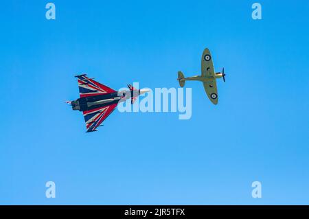 Eine Spitfire aus dem Zweiten Weltkrieg und ein moderner Typhoon-Jet-Kämpfer fliegen an der jährlichen Eastbourne Airshow vorbei, einer der größten kostenlosen Veranstaltungen dieser Art in der Stockfoto