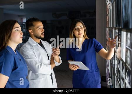 Eine Gruppe von Chirurgen-Praktikanten untersucht die fetale Entwicklung in verschiedenen Stadien der Schwangerschaft. Konzept der Gesundheitserziehung. Medizinstudenten im Klassenzimmer Stockfoto