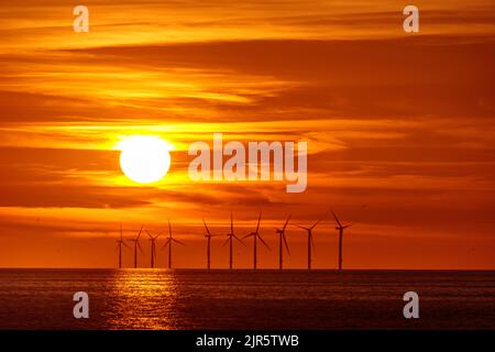 Sonnenuntergang über dem Offshore-Windpark Gwynt-y-Môr an der Küste von Nordwales Stockfoto