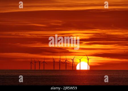 Sonnenuntergang über dem Offshore-Windpark Gwynt-y-Môr an der Küste von Nordwales Stockfoto