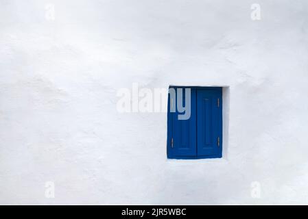 Fassade des griechischen weißen Hauses mit blauen Fenstern Stockfoto