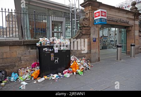 Waverley Station, Edinburgh, Schottland, Großbritannien. 22.. August 2022. Es war schlimm genug, um im Urlaub anzureisen und von dumpfem und niesem Wetter begrüßt zu werden, obwohl die Temperatur bei 17 Grad Celsius liegt, aber noch schlimmer sind Mülltonnen auf den Gehwegen, die sich stapelten und mit weggeworfenen Müll direkt vor dem Eingang des Bahnhofs überfüllten. Dies ist darauf zurückzuführen, dass die Reinigungskräfte des Stadtrats von Edinburgh an ihrem fünften Tag eines elftägigen Streiks über die Bezahlung sind. Quelle: Arch White/alamy Live News. Stockfoto