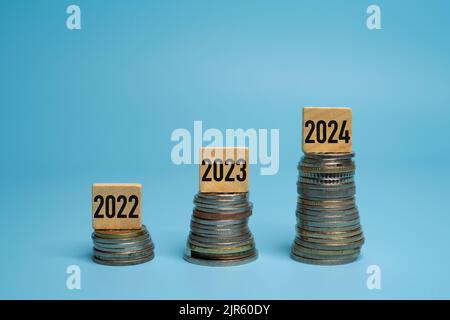 Ein paar Stapel Münzen auf dem Tisch. Das Konzept des Inflationswachstums für die Jahre 2022, 2023 und 2024 Stockfoto