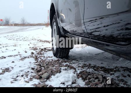 Geländewagen bereit für die Winterfahrt auf der verschneiten Landstraße Stockfoto