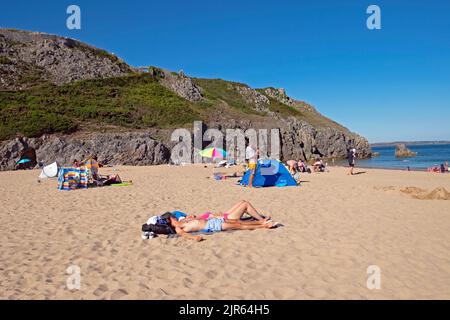 Menschen Urlauber Paar liegen entspannt am Sandstrand im Sommer in Barafundle Bay, Stackpole in Pembrokeshire West Wales UK KATHY DEWITT Stockfoto