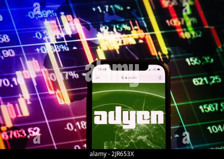 KONSKIE, POLEN - 10. August 2022: Smartphone mit Logo der Firma Adyen im Hintergrund des Börsendiagramms Stockfoto