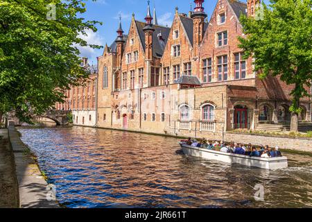 Touristen genießen eine geführte Bootsfahrt um die Kanäle von Brügge, Belgien Stockfoto