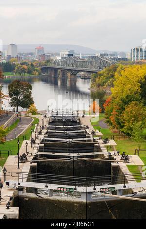 Rideau Kanal Rideau Waterway Herbst rote Blätter Landschaft. Herbstlaub in Ottawa, Ontario, Kanada. Alexandra Bridge im Hintergrund. Stockfoto