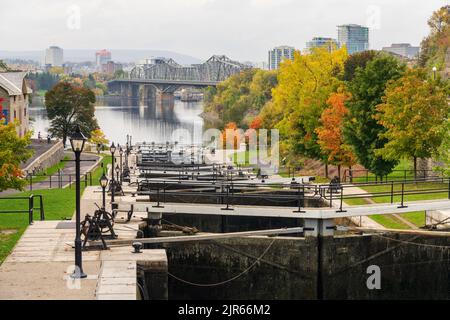 Rideau Kanal Rideau Waterway Herbst rote Blätter Landschaft. Herbstlaub in Ottawa, Ontario, Kanada. Alexandra Bridge im Hintergrund. Stockfoto