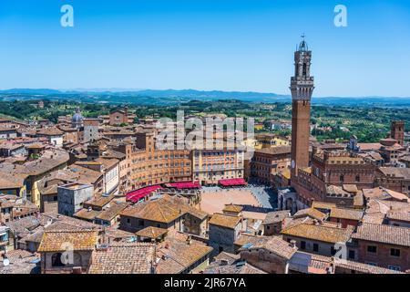 Luftaufnahme über die Dächer zur Piazza del Campo mit dem Torr del Mangia (Glockenturm) rechts vom Aussichtspunkt Facciatone in Siena, Toskana, Italien Stockfoto