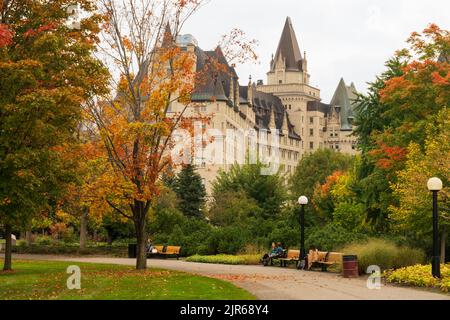 Ottawa, Ontario, Kanada - Oktober 16 2021 : Majors Hill Park Herbstlandschaft mit roten Blättern. Fairmont Chateau Laurier im Hintergrund. Stockfoto