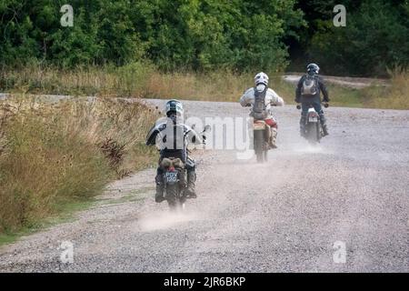 Eine Gruppe von drei Motorradfahrern (Biker), die ihre Offroad-Motorräder auf einer staubigen Sommerpiste fahren Stockfoto