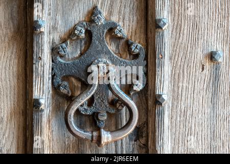 Detail der schweren Kirche Türgriff auf getäfelten alten hölzernen schweren gemaserten Tür Stockfoto