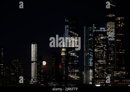 Panoramablick auf die Wolkenkratzer des Hudson Yard in New York City, Manhattan, und heller Vollmond hinter Gebäuden Stockfoto