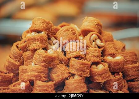 Kadayif traditionelle Ottomane und arabisches Dessert mit Zuckernudeln und Nüssen Füllung. Gebäck und türkische Baklava zum Verkauf Stockfoto