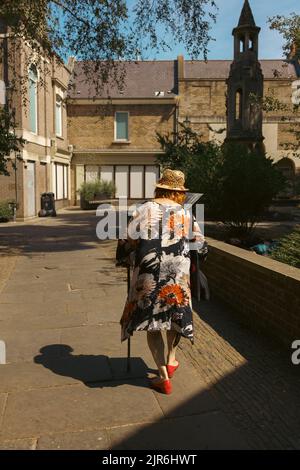 Richmond, London | UK - 2022.08.14: Ältere Dame bei einem Spaziergang in Richmond upon Thames an einem sonnigen Tag Stockfoto