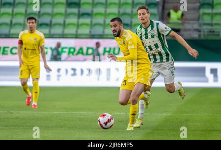 Budapest, Ungarn – 13. Juli 2022. Ferencvaros Mittelfeldspieler Kristoffer Zachariassen gegen den Tobol-Verteidiger Aleksa Amanovic während der UEFA Champions League Stockfoto