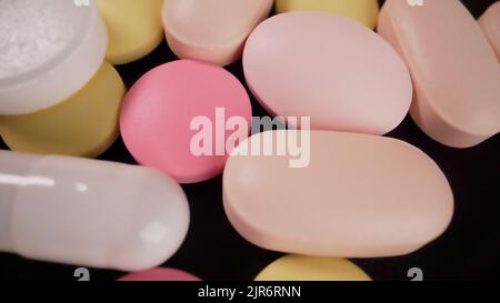 Tabletten in verschiedenen Größen aus der Nähe. Medikamente Tabletten, Kapseln, Pillen verschiedener Art, Größen und Farben, in großen Mengen gestapelt.farbige Vitamin schließen U Stockfoto