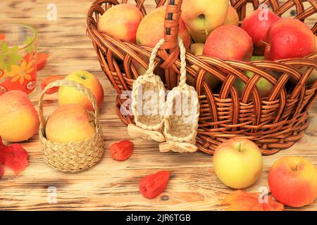 Rote Äpfel liegen in Korbteller auf Holztisch. Reife leckere Äpfel für Marmelade Stockfoto