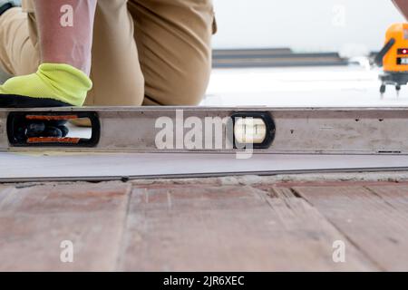 Der Master misst die Höhe der Bodenfläche. Stockfoto