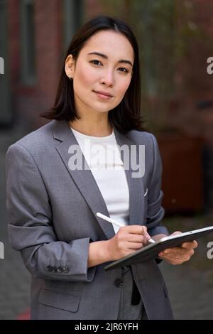 Junge selbstbewusste asiatische Geschäftsfrau Unternehmer hält Tablet, Porträt. Stockfoto